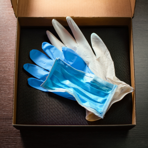 A surgeon’s gloves beside a box symbolising emergency call-outs.